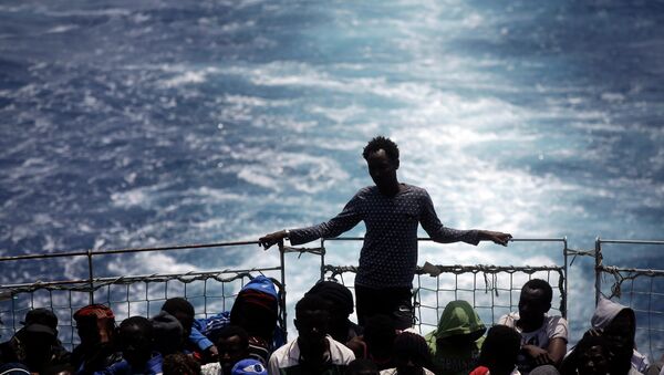 A file photo showing migrants sit on the deck of the Belgian Navy vessel Godetia after they were saved at sea during a search and rescue mission in the Mediterranean Sea off the Libyan coasts, Wednesday, June 24, 2015. - Sputnik International
