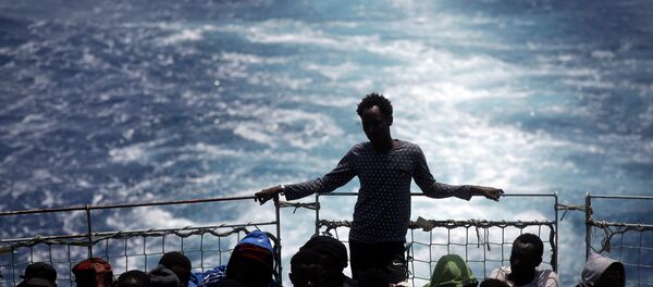 Migrants sit on the deck of the Belgian Navy vessel Godetia after they were saved at sea during a search and rescue mission in the Mediterranean Sea off the Libyan coasts, Wednesday, June 24, 2015. Migrants sit on the deck of the Belgian Navy vessel Godetia after they were saved at sea during a search and rescue mission in the Mediterranean Sea off the Libyan coasts, Wednesday, June 24, 2015. - Sputnik International