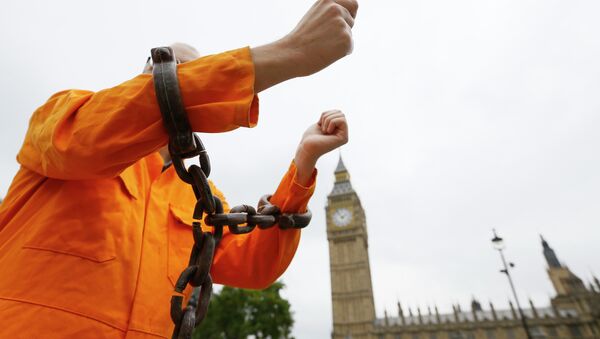 A protester holds up his chained arms during a protest against the Guantanamo Bay detention camp, in Parliament Square in London, Wednesday, Oct. 15, 2014 - Sputnik International