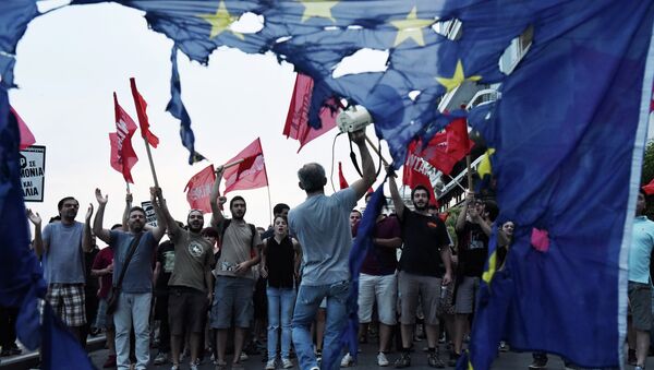 Members of left wing parties shout slogans behind a burning European Union flag during an anti-EU protest in the northern Greek port city of Thessaloniki, Sunday, June 28, 2015 - Sputnik International