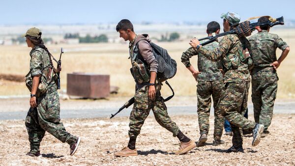 Kurdish People's Protection Units (YPG) fighters walk with their weapons at the eastern entrances to the town of Tal Abyad in the northern Raqqa countryside, Syria, June 14, 2015 - Sputnik International