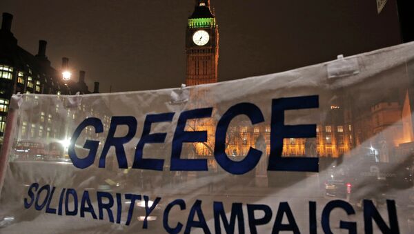 Backdropped by the Houses of Parliament in central London, protesters hold a banner at a rally to show solidarity with Greece. File photo - Sputnik International