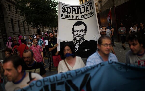 Protestors march as they carry a flag with a caricature representing Span's Prime Minister Mariano Rajoy dressed in a nazi uniform reading Spanish, out of Europe as they protest against the Public Security Law in Madrid, Spain - Sputnik International