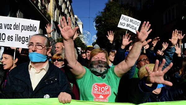 Demonstrators hold placards reading A country with a gag doesn't move as they protest against the new public security law (ley mordaza) approved by the lower house of parliament, in Madrid on December 20, 2014 - Sputnik International