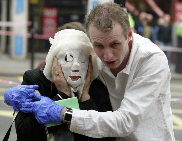 A July 7, 2005, file photo of Paul Dadge, right, as helps injured tube passenger Davinia Turrell away from Edgware Road tube station in London following an explosion. - Sputnik International