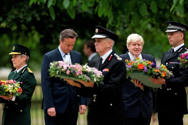 Britain's Prime Minister David Cameron, second from left, and London Mayor Boris Johnson, fourth from left, stand beside senior representatives from the ambulance, left, fire, third left, and police services as they wait to lay wreaths at the 7/7 memorial in Hyde Park in London, Tuesday, July 7, 2015. - Sputnik International