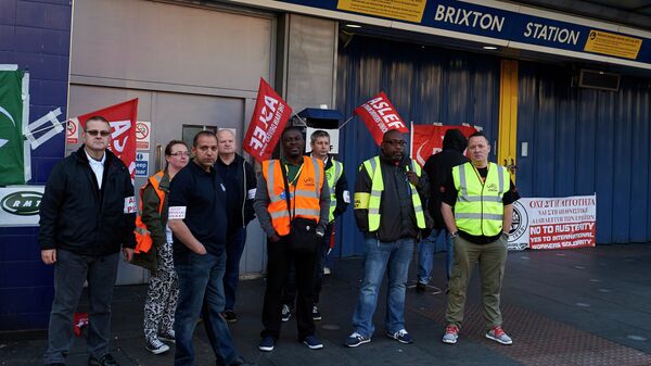 Protesters from the ASLEF and RMT unions stand at the locked gates of Brixton underground station during a tube strike in London on July 9, 2015 - Sputnik International