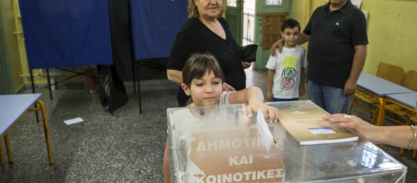 A child casts her grandmother's ballot during a referendum vote in Athens, Greece, July 5, 2015 - Sputnik International