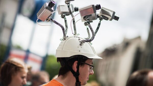 Chairman of Hesse's Pirate Party Volker Berkhout wears a hat with mock surveillance cameras during a demonstration against spying activities of the US intelligence agency NSA and its German partner service BND in Frankfurt am Main, central Germany, on May 30, 2015 - Sputnik International