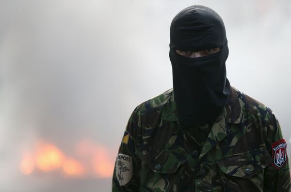 A participant looks on during a rally held by members of the far-right radical group Right Sector, representatives of the Ukrainian volunteer corps and their supporters, with tyres set on fire seen in the background, in central Kiev, Ukraine, July 3, 2015 - Sputnik International