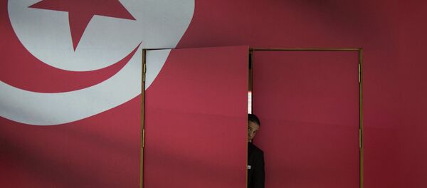 A Tunisian guard looks out of the main gate of media center for its parliamentary election in Tunis, capital of Tunisia, on Oct. 25, 2014 A Tunisian guard looks out of the main gate of media center for its parliamentary election in Tunis, capital of Tunisia, on Oct. 25, 2014 - Sputnik International