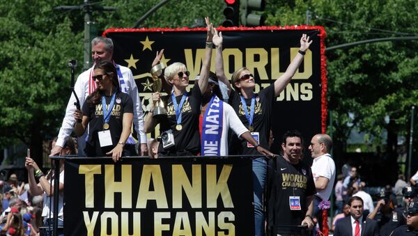 U.S. women's soccer team midfielder Megan Rapinoe, center, holds up the World Cup trophy during the ticker tape parade to celebrate the U.S. women's soccer team World Cup victory, Friday, July 10, 2015, in New York - Sputnik International