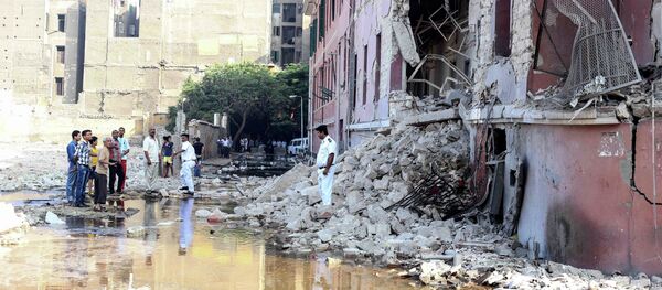 A policeman stands at the base of the crumbled facade of the Italian consulate following a blast that killed at least one person in Cairo, Egypt, Saturday, July 11, 2015 - Sputnik International