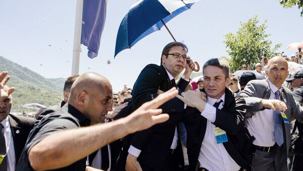 Bodyguards try to protect Serbian Prime Minister Aleksandar Vucic (C) from stones hurled at him by an angry crowd at the Potocari Memorial Center, near the eastern Bosnian town of Srebrenica on July 11, 2015 - Sputnik International