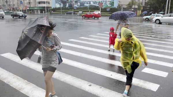 Pedestrians hold their umbrellas against strong wind China - Sputnik International