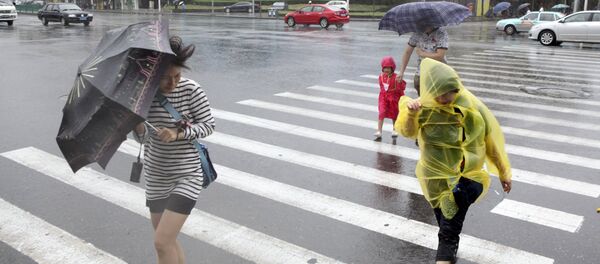 Pedestrians hold their umbrellas against strong wind China - Sputnik International