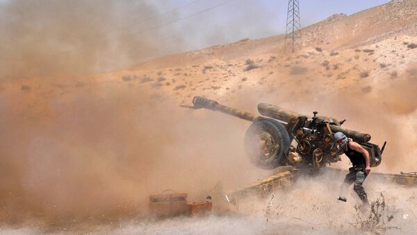 A Syrian army soldier fires artillery shells towards Islamic State (IS) group jihadists in northeastern Palmyra on May 17, 2015 - Sputnik International