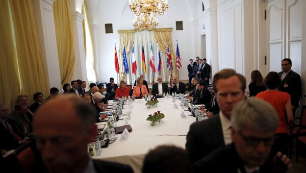 Iranian Foreign Minister Mohammad Javad Zarif (C) sits next to European Union High Representative for Foreign Affairs and Security Policy Federica Mogherini as they meet with foreign ministers from the U.S., France, Russia, Germany, China and Britain at the hotel where the Iran nuclear talks meetings are being held in Vienna, Austria July 6, 2015 - Sputnik International