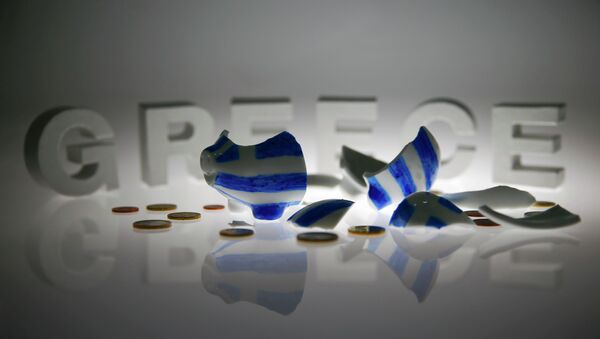 A broken piggybank painted in the colours of the Greek flag lies amongst various euro coins in front of letters spelling the word 'GREECE' in this picture illustration taken in Berlin, Germany June 30, 2015 - Sputnik International