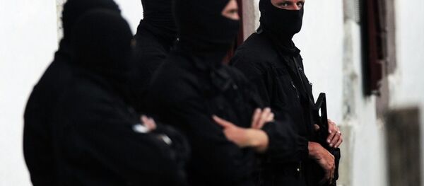 Police officers stand guard outside of a house after arresting two presumed member of the armed Basque separatist group Euskadi Ta Askatasuna (ETA) in Osses on July 7, 2015. - Sputnik International