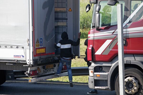 A migrant goes inside a lorry to attempt to cross the English Channel, in Calais, northern France, Wednesday, June 24, 2015. A migrant goes inside a lorry to attempt to cross the English Channel, in Calais, northern France, Wednesday, June 24, 2015. - Sputnik International