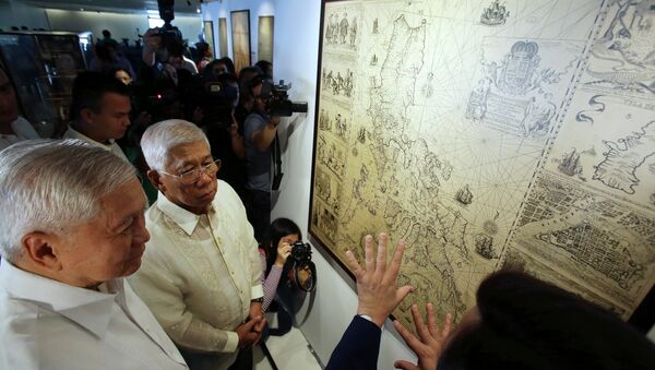Philippine Foreign Affairs Secretary Albert del Rosario, left, and Defense Secretary Voltaire Gazmin, center, listen during a cartographic exhibit entitled “Historical Truths and Lies: Scarborough Shoal in Ancient Maps.” - Sputnik International