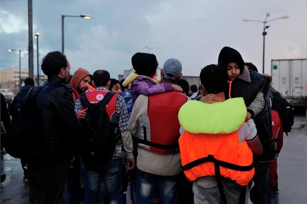 Temporary detained migrants walk at the port at Greek island of Kos - Sputnik International