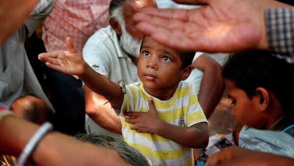 A child stretches arms to receive free food - Sputnik International
