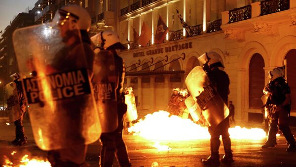 Riot police stand amongst the flames from exploded petrol bombs thrown by a small group of anti-austerity demonstrators in front of parliament in Athens, Greece July 15, 2015 - Sputnik International