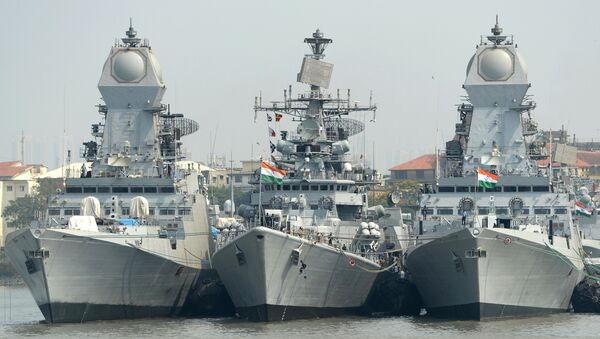 Indian naval sailors on a rubber inflatable boat pass naval warships at the Naval Dockyard in Mumbai - Sputnik International