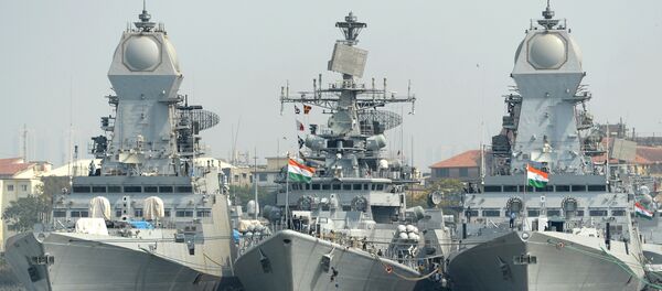 Indian naval sailors on a rubber inflatable boat pass naval warships at the Naval Dockyard in Mumbai - Sputnik International