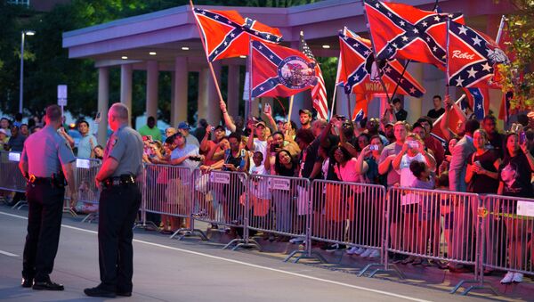 People wave Confederate flags outside the hotel that President Barack Obama is staying the night, on Wednesday, July 15, 2015, in Oklahoma City. Obama is traveling in Oklahoma to visit El Reno Federal Correctional Institution. - Sputnik International