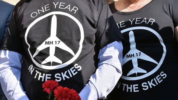 People wearing t-shirts bearing a drawing of a plane and slogans reading  MH 17, One year in the skies hold flowers to the Dutch embassy in Kiev on July 17, 2015 - Sputnik International