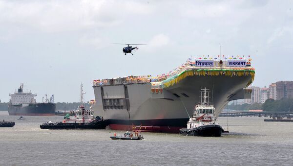 Tugboats guide the indigenously-built aircraft carrier INS Vikrant as it leaves the Cochin Shipyard Limited's dock after its launch in Kochi on August 12, 2013 - Sputnik International