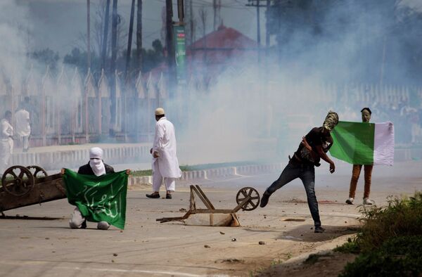 Kashmiri Muslims protesters hold representation of a Pakistani flag, right, and an Islamic flag as they clash with Indian policemen and paramilitary soldiers during a protest near Eidgah, or an open-air mosque, in Srinagar, Indian controlled Kashmir, Saturday, July 18, 2015 Kashmiri Muslims protesters hold representation of a Pakistani flag, right, and an Islamic flag as they clash with Indian policemen and paramilitary soldiers during a protest near Eidgah, or an open-air mosque, in Srinagar, Indian controlled Kashmir, Saturday, July 18, 2015 - Sputnik International