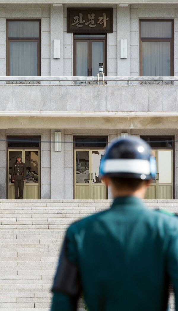 A South Korean JSA guard (front R) and North Korean guard (L) stand guard opposite each other at the border of the truce village of Panmunjom in the Demilitarized zone (DMZ) dividing the two Koreas. File photo. A South Korean JSA guard (front R) and North Korean guard (L) stand guard opposite each other at the border of the truce village of Panmunjom in the Demilitarized zone (DMZ) dividing the two Koreas. File photo. - Sputnik International