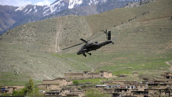 A US Army AH-64 Apache helicopter flies over a village in Naray, in Afghanistan's eastern Kunar province on April 16, 2009 - Sputnik International