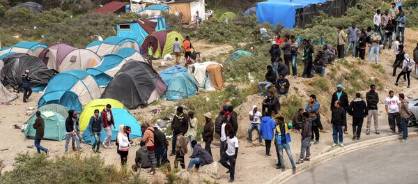 Migrants stand next to tents in the New Jungle in Calais on June 17, 2015 near the ferry port of Calais, northern France Migrants stand next to tents in the New Jungle in Calais on June 17, 2015 near the ferry port of Calais, northern France - Sputnik International