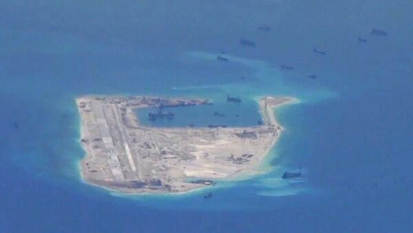 Chinese dredging vessels are purportedly seen in the waters around Fiery Cross Reef in the disputed Spratly Islands in the South China Sea in this still file image from video taken by a P-8A Poseidon surveillance aircraft provided by the United States Navy - Sputnik International