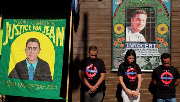 Cousins Alessandro Pereira, right, Vivian Figueiredo and friend Erionaldo da Silva, left, observe a minute's silence on the 10-year-anniversary of the death of 27-year-old Brazilian electrician Jean Charles de Menezes, shot by British police who thought he was a terrorist in the tense aftermath of deadly 2005 London subway bombings, at Stockwell station in London, Wednesday, July 22, 2015. - Sputnik International