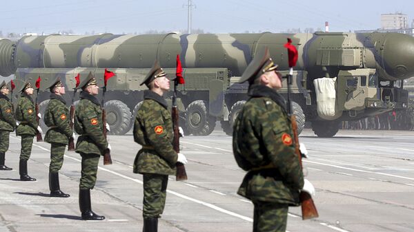 Russian soldiers stand near a Topol-M ICBM while participating in a rehearsal for the nation's Victory Day parade outside Moscow in Alabino on April 22, 2008 - Sputnik International