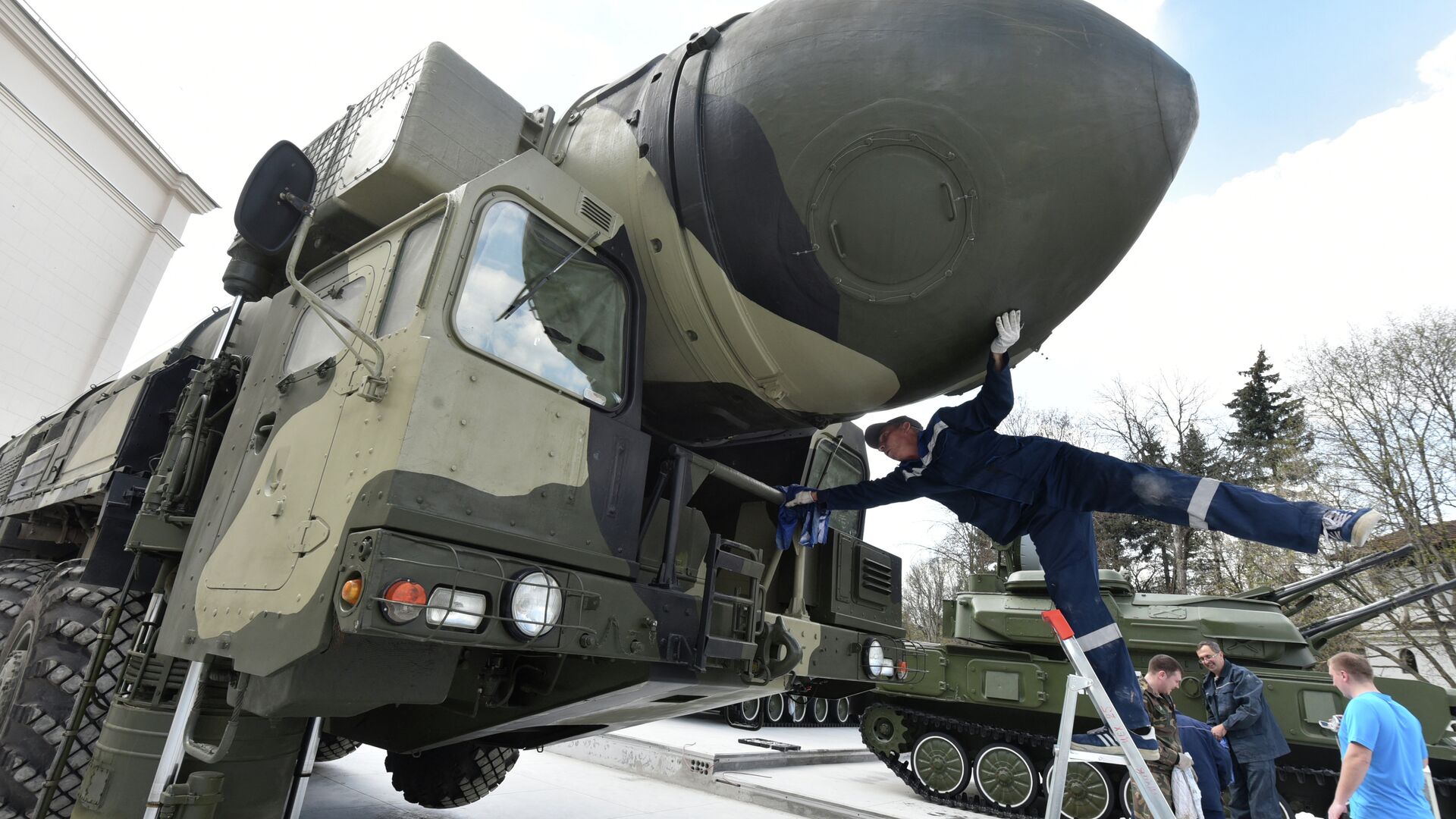 An employee cleans a Topol-M intercontinental ballistic missile launcher at an open-air military exhibition in Moscow on April 29, 2015 - Sputnik International, 1920, 19.01.2022