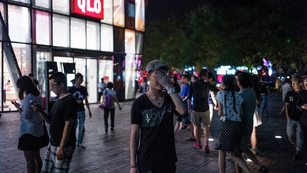 In this picture taken on July 15, 2015, people gather in front of a Uniqlo clothes store in Beijing. - Sputnik International