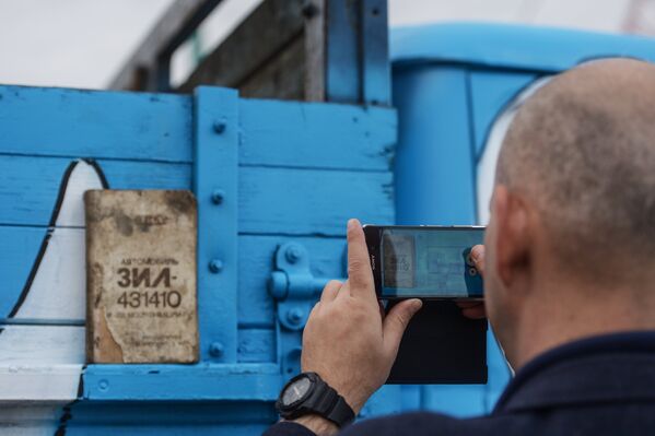A visitor is taking a photo of the ZiL 431410 truck. - Sputnik International
