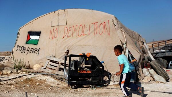 A Palestinian boy runs outside his family tent in the village of Susiya, south of the West Bank city of Hebron. - Sputnik International