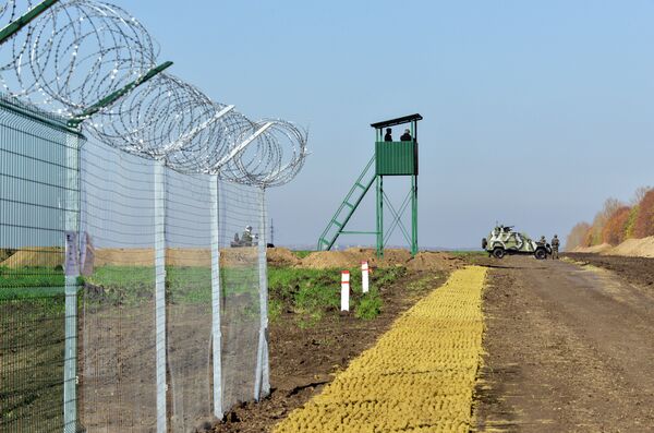 Urkainian border guards stand near an Armoured Personnel Carrier (APCs) parked near a newly constructed part of the border near the Goptivka border crossing on the Urkainian-Russian border, north of Kharkiv, eastern Ukraine, on October 15, 2014 Urkainian border guards stand near an Armoured Personnel Carrier (APCs) parked near a newly constructed part of the border near the Goptivka border crossing on the Urkainian-Russian border, north of Kharkiv, eastern Ukraine, on October 15, 2014 - Sputnik International