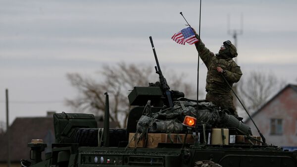 A member of US Army’s 2nd Cavalry Regiment raises the US flag on a Stryker vehicle during the ''Dragoon Ride'' military exercise, in Salociai some 178 kms (110 miles) north of the capital Vilnius, Lithuania, Monday, March 23, 2015 - Sputnik International