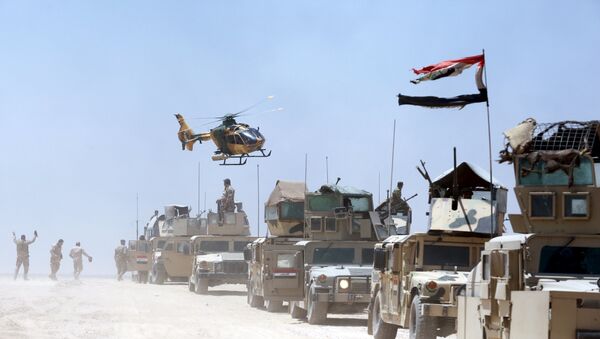 An Iraqi helicopter flies over military vehicles in Husaybah, in Anbar province July 22, 2015 - Sputnik International