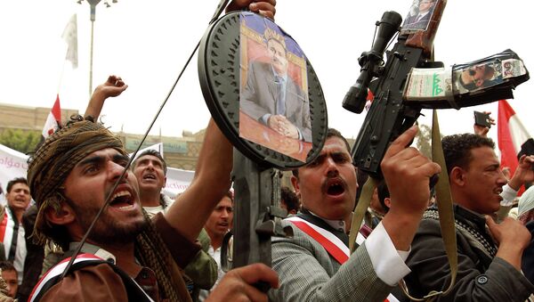 Yemeni protesters hold rifels with portraits of Yemen's former president Ali Abdullah Saleh hung on them during a demonstration against airstrikes carried out by the Saudi-led Arab coalition against Huthi militia in the capital Sanaa on April 3, 2015 - Sputnik International