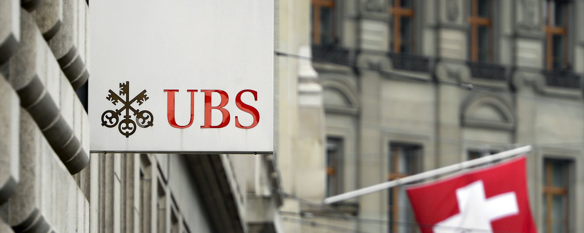 A Swiss flag is seen behind a sign of Swiss bank giant UBS on June 11, 2013 in Basel. - Sputnik International, 1920, 03.04.2023